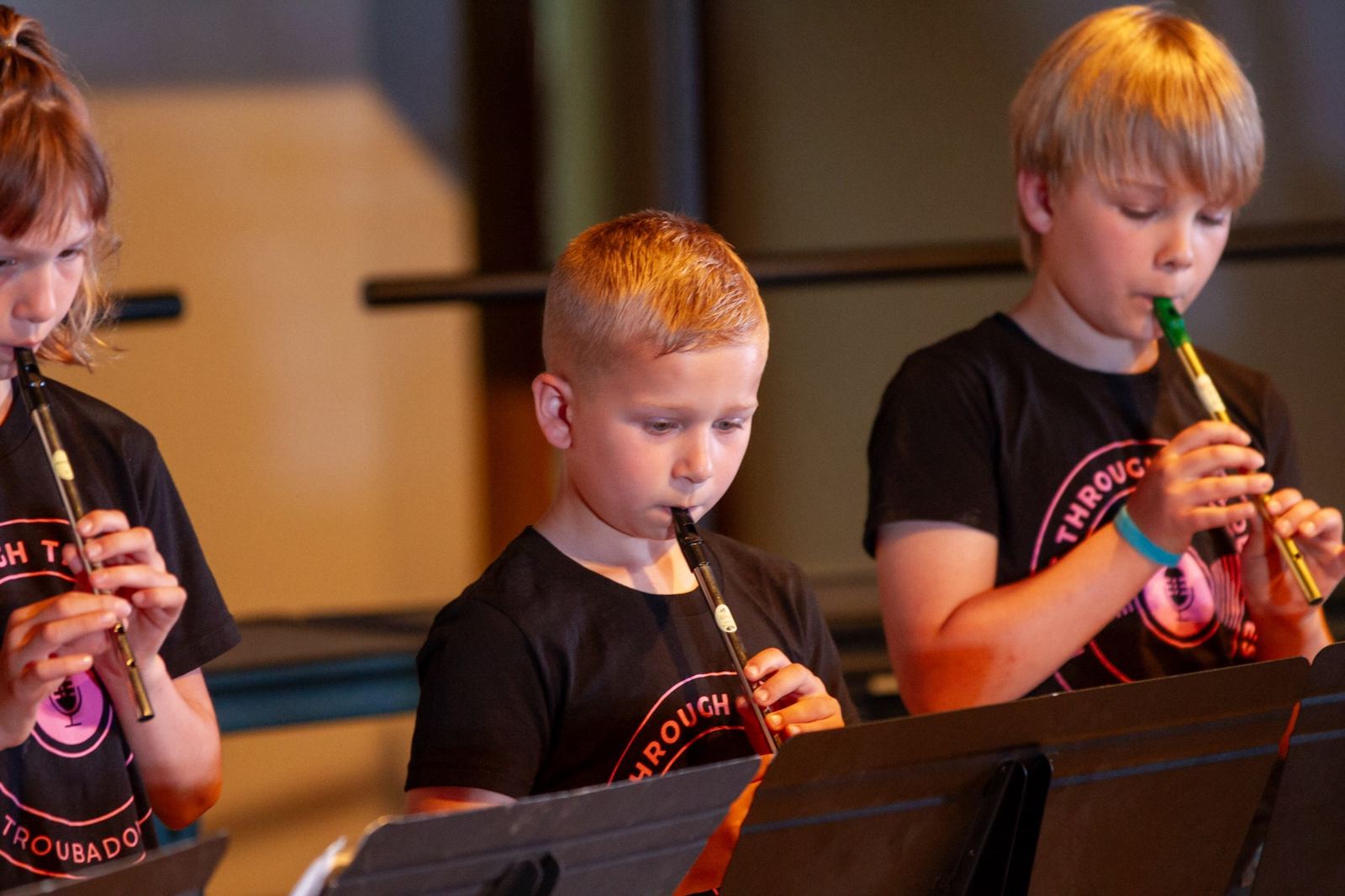 Young students playing tin whistles