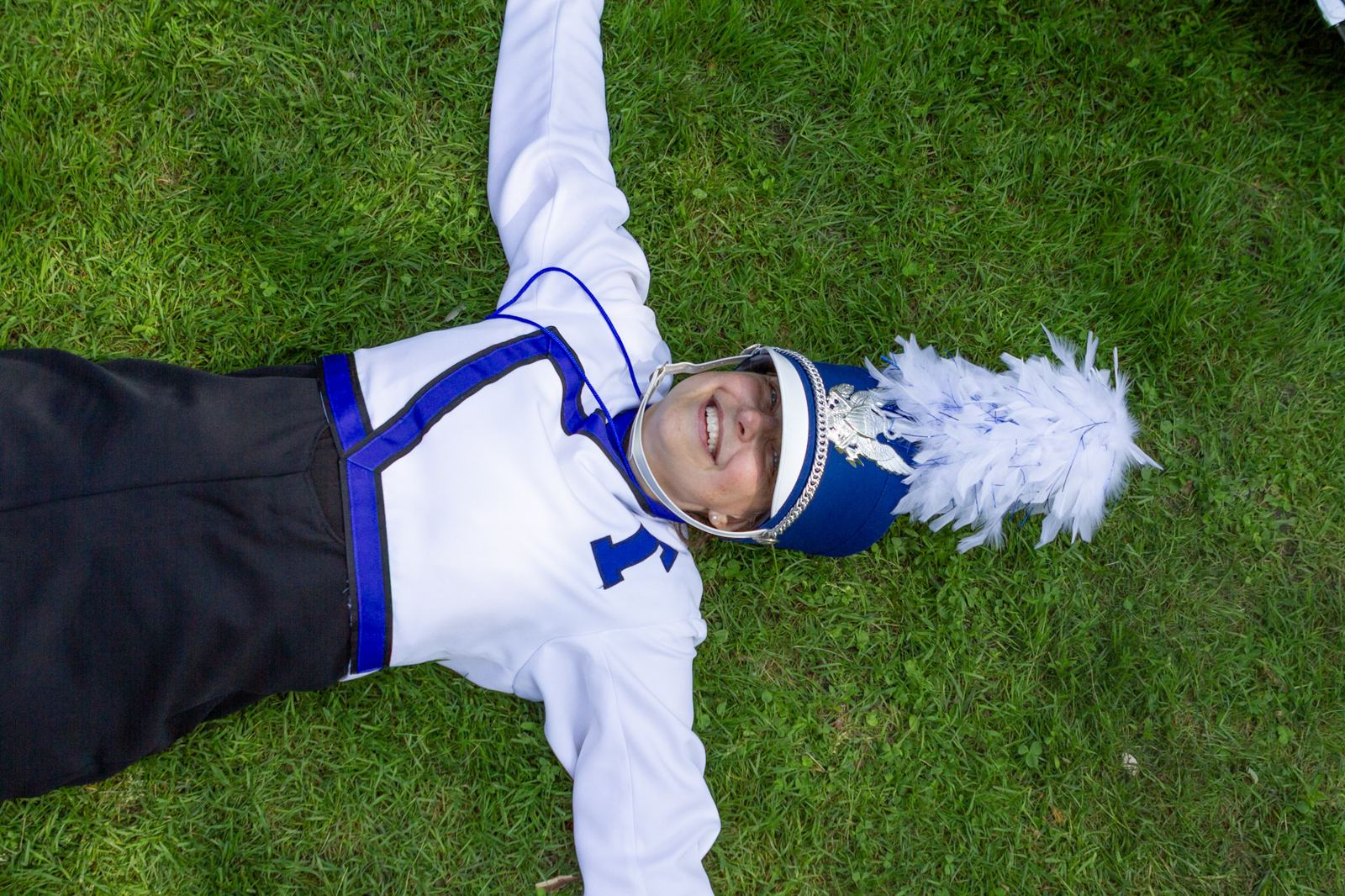 Marching band student smiling in the grass