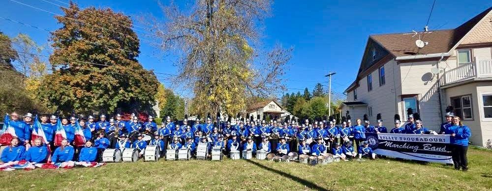 Valley Troubadours Marching Band posing with their banner