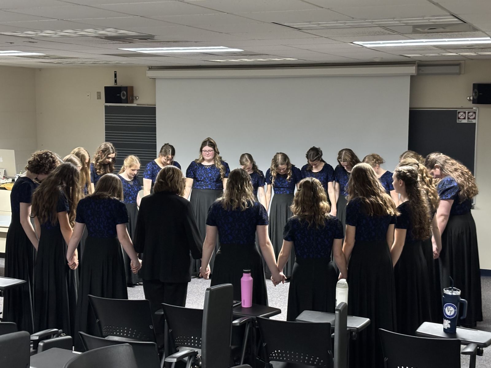 Choir students standing in a circle before a performance