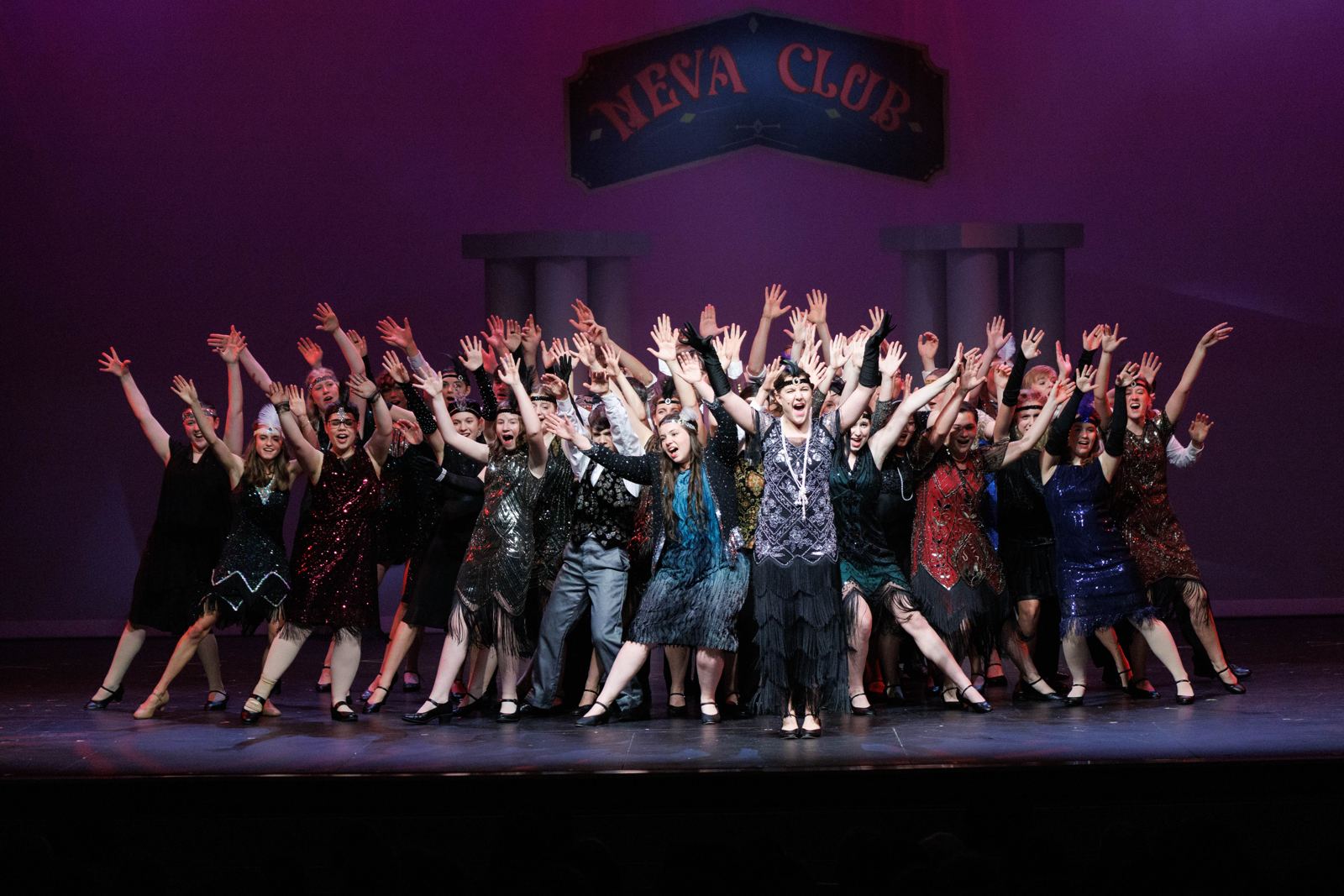 Musical theater cast celebrating on stage